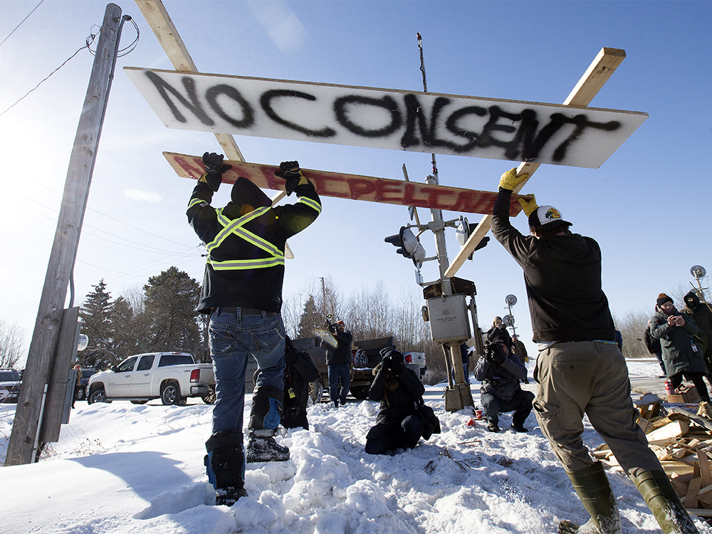  Counter protesters tear down a blockade along the CN rail line near 213 Street and 110 Avenue, in Edmonton Wednesday Feb. 19, 2020. A separate group of protesters had set up the blockade in solidarity with Wet’suwet’en Hereditary Chiefs. Photo by David Bloom