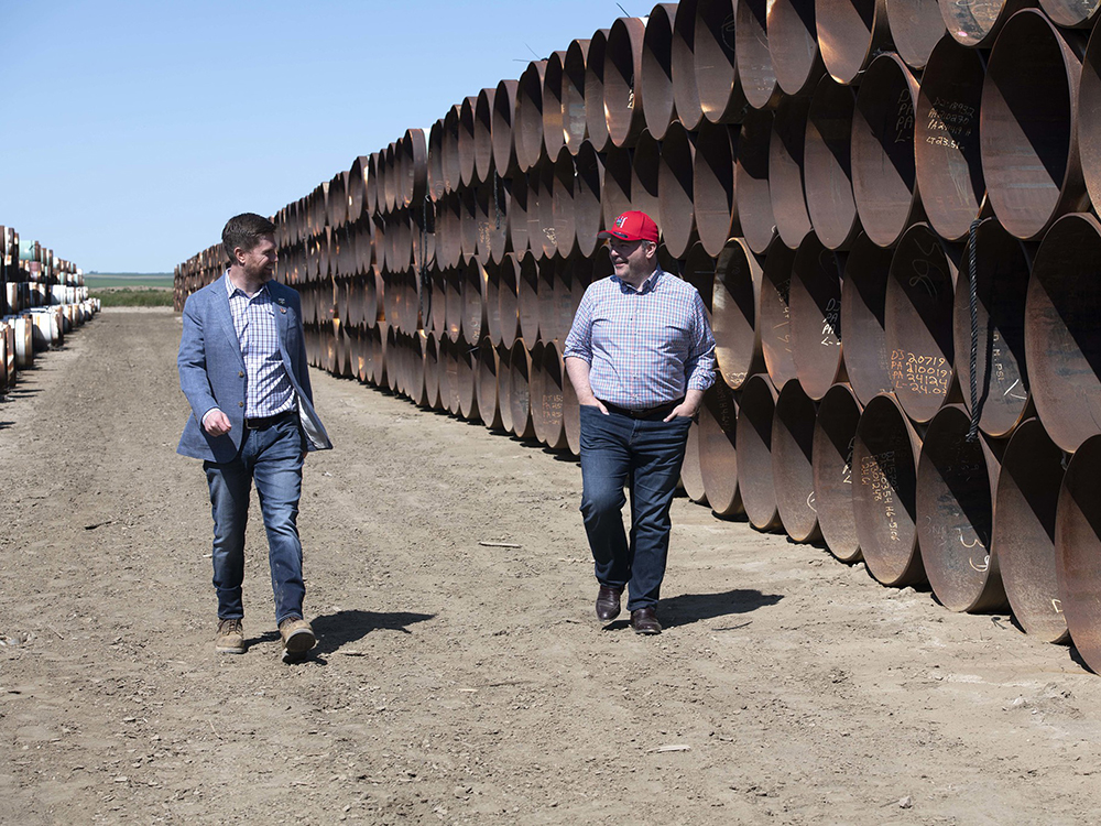  Premier Jason Kenney (right) in Oyen, Alta., surrounded by pipes for the Alberta segment of the Keystone XL pipeline.