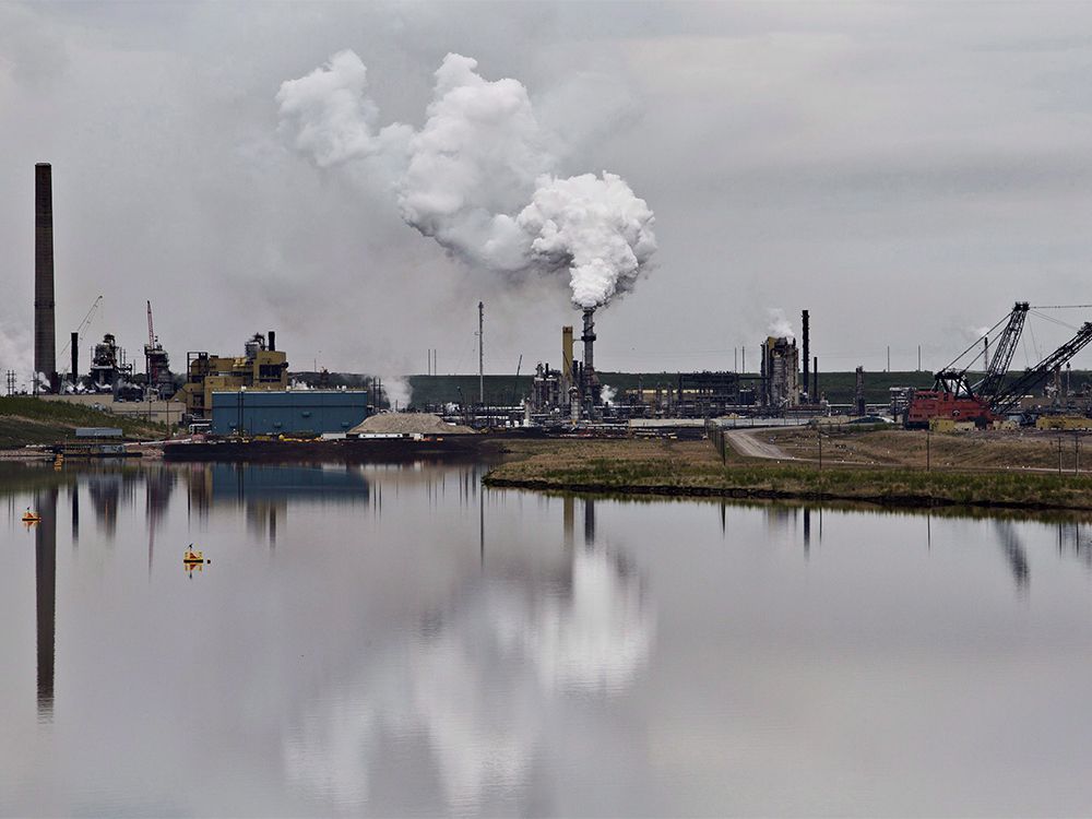  CP-Web. An oil sands extraction facility is reflected in a tailings pond near the city of Fort McMurray, Alberta on Sunday June 1, 2014.