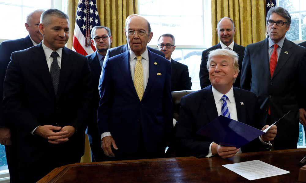  U.S. President Donald Trump smiles after announcing a permit for TransCanada Corp’s Keystone XL oil pipeline on March 24, 2017, while TransCanada chief executive Russell Girling’ left, stands by. President-elect Joe Biden has previously said that as president he would cancel the permit.