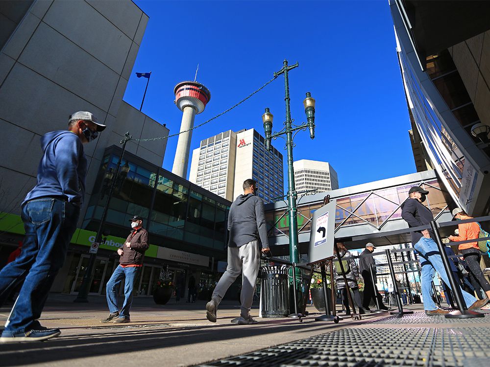  People line up for vaccines outside the Telus Convention Centre in downtown Calgary on Wednesday, April 21, 2021.