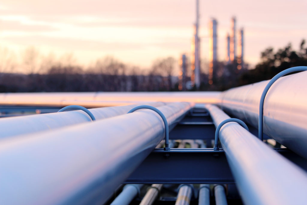 Steel long pipes in crude oil factory during sunset