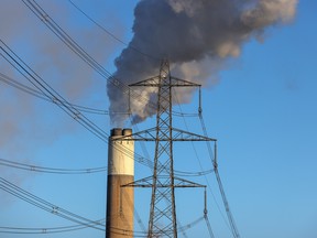 An electricity pylon in front of a cooling tower at Uniper SE's coal-fired power station in Ratcliffe-on-Soar, U.K., Dec. 2, 2021.