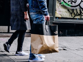 A pedestrian carries a North Face shopping bag in the SoHo neighbourhood of New York on Oct. 24, 2021.