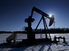 A pumpjack pumps oil from a well on a farmer's frozen field near Pigeon Lake, Alta.