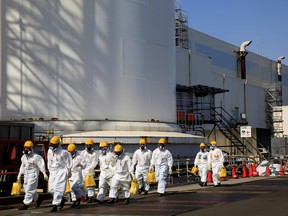 Workers walk near No. 2 and No. 3 reactor buildings at the tsunami-crippled Fukushima Daiichi nuclear power plant in March.