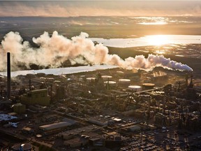 The setting sun reflects off a tailings pond behind Syncrude’s oilsands upgrading facility north of Fort McMurray in 2013.