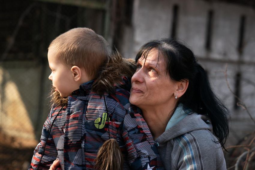 A woman and her grandson survey the damage done at the site of a Russian missile attack in Ukraine.