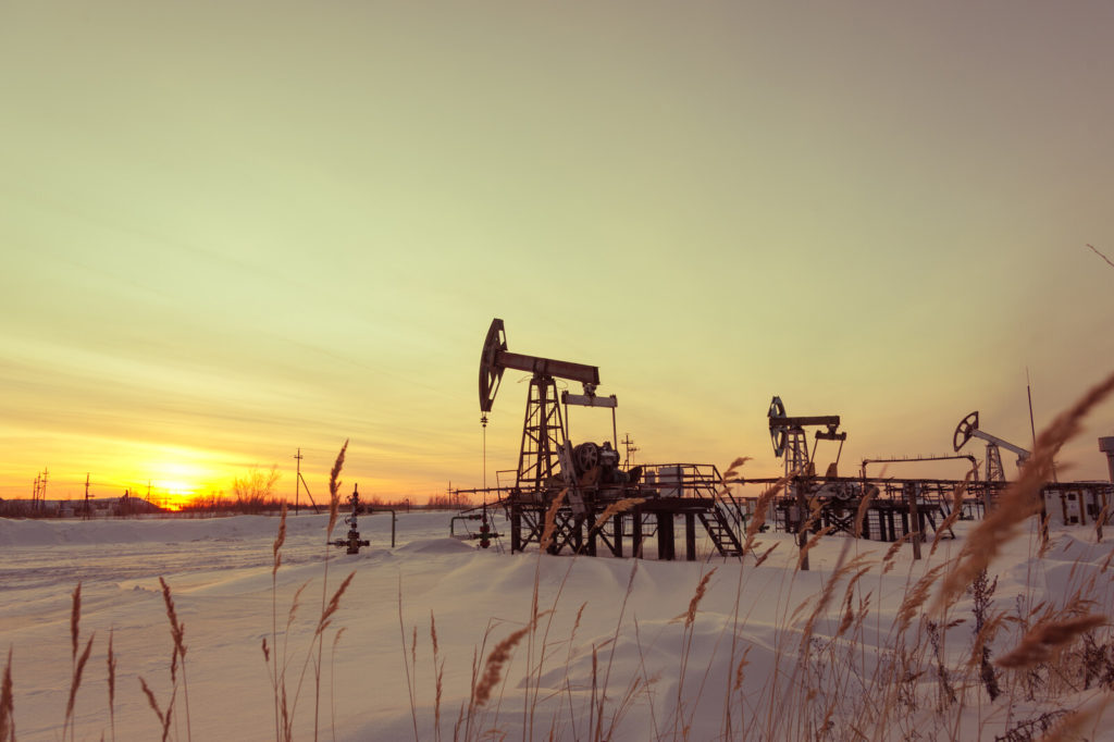 Winter pumpjack with sun setting