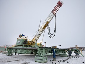 Workers remove caps from drill pipes on a Precision Drilling rig near Alix, Alta., in 2009.
