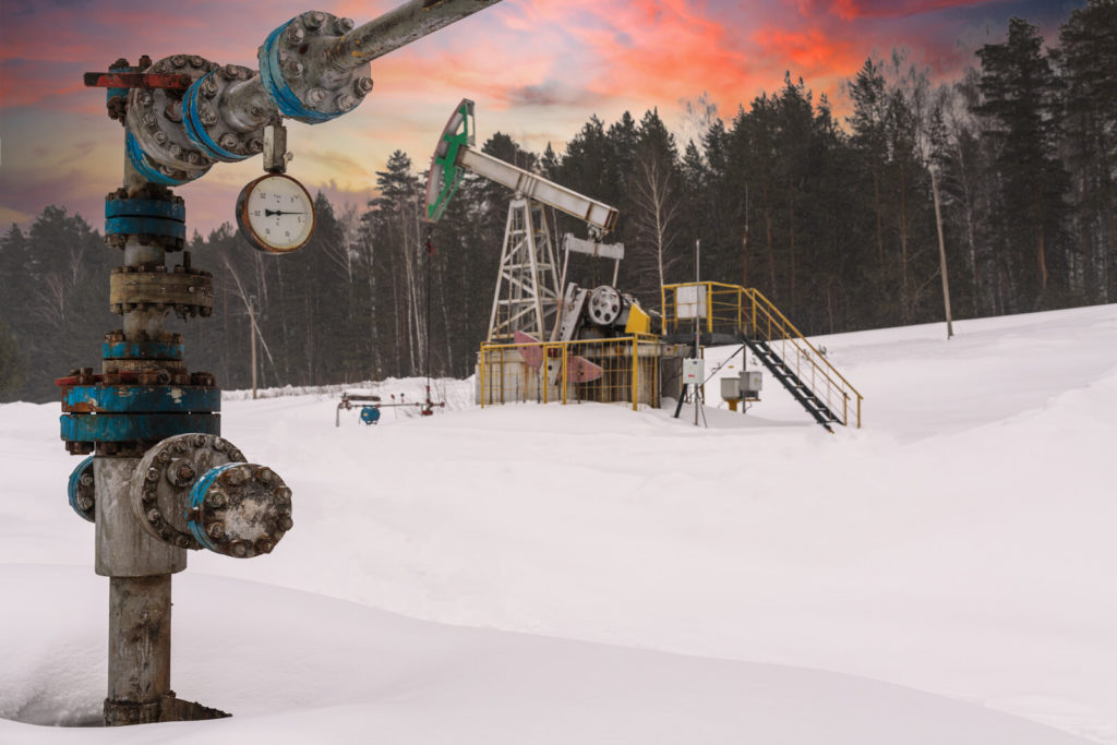 Pump jack and well site in winter.