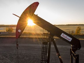 A pumpjack draws out oil and gas from a well head as the sun sets near Calgary, Alta., Sunday, Oct. 9, 2022.