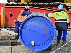 Workers are seen next to a pipe at the construction site of the Nord Stream 2 gas pipeline in Lubmin, northeastern Germany. The country suspended the pipeline project last February in response to Russia’s invasion of Ukraine.