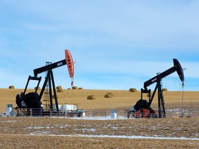 FILE PHOTO: Pumpjacks are framed by a wheat field near Cochrane on Wednesday, March 4, 2020.