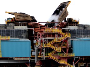 Heavy hauler trucks unload into a crusher at the Fort Hills oilsands project on Monday, September 10, 2018.