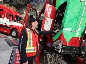 Shawn Robinson, who has driven trucks for Mullen Group for 21 years, shows the natural gas storage tanks on a new truck in Calgary on Tuesday, April 18, 2023. The trucks were on display during the announcement of a $70 million joint development agreement between Tourmaline and Clean Energy to build CNG stations in Western Canada.