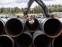 Pipe for the Trans Mountain pipeline is unloaded in Edson, Alta. on June 18, 2019.